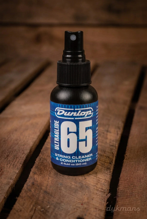 Dunlop 6582 Ultra Glide 65 String Cleaner & Conditioner 60 ml met blauw etiket op een warme houten achtergrond